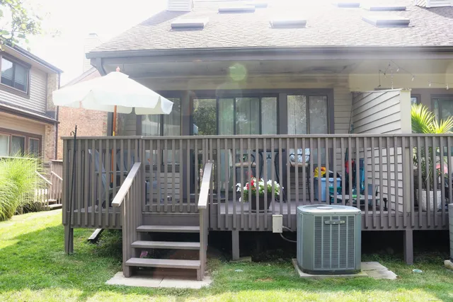 a view of a patio with table and chairs under an umbrella with wooden floor