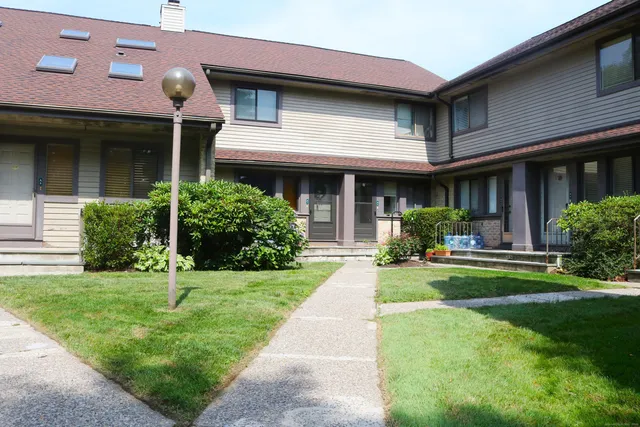 a front view of a house with a yard and potted plants