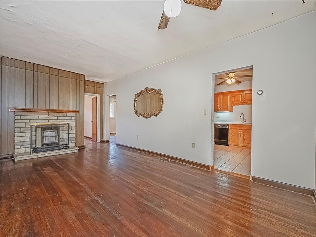 1694 Dime Road Vandergrift, PA 15690 - Photo 5 of 35 an empty room with wooden floor and fireplace