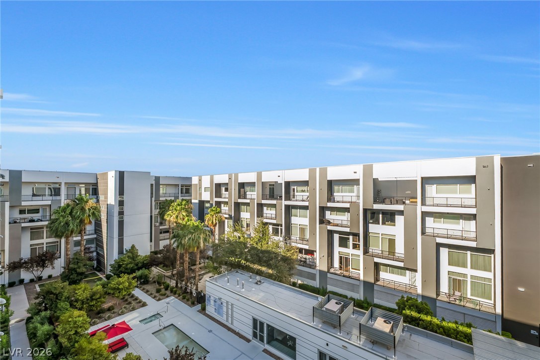 2775 West Pebble Road, Unit 505 Las Vegas, NV 89123 - Photo 18 of 26 Modern multi-story complex with private balconies overlooking lush landscaping and inviting communal pools.