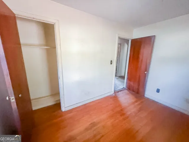 an empty room with wooden floor and a window