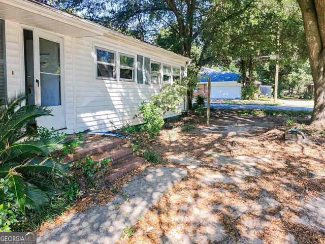 a view of a house with backyard and sitting area