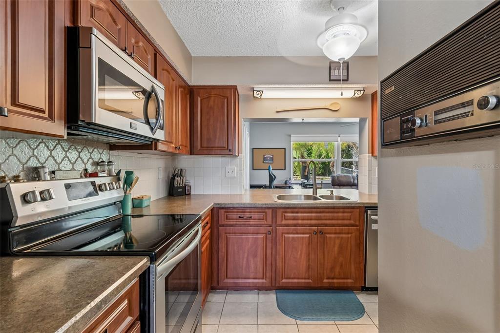 5478 Waycross Drive Spring Hill, FL 34606 - Photo 12 of 29 a kitchen with stainless steel appliances granite countertop a stove a sink and a microwave