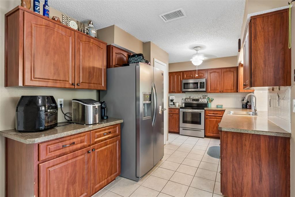 5478 Waycross Drive Spring Hill, FL 34606 - Photo 15 of 29 a kitchen with stainless steel appliances granite countertop a refrigerator stove and sink