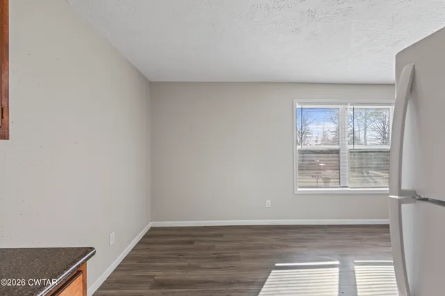 a kitchen with stainless steel appliances granite countertop a refrigerator a stove and a sink with wooden floor