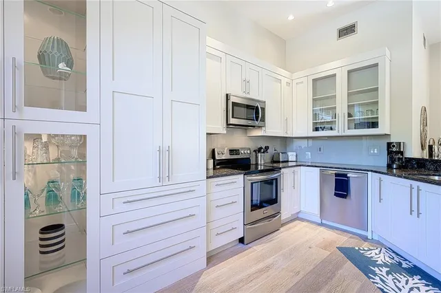 a kitchen with granite countertop a stove a sink and a microwave