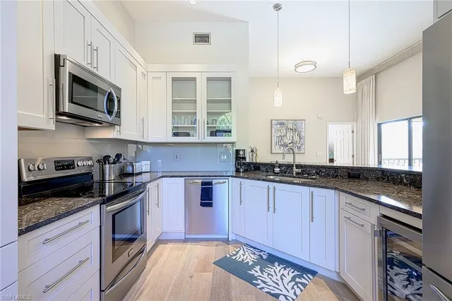 a kitchen with stainless steel appliances granite countertop a stove a sink and a microwave