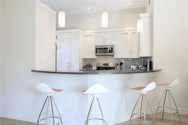 a kitchen with stainless steel appliances granite countertop a stove a sink and a white cabinets