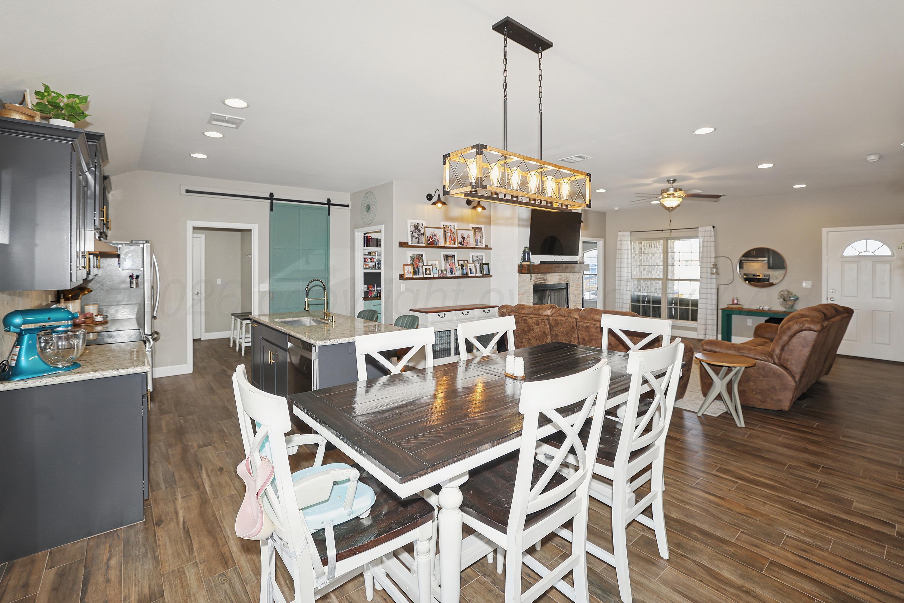 9715 Mossberg Street Canyon, TX 79015 - Photo 32 of 32 a view of a dining room and livingroom with furniture wooden floor a chandelier