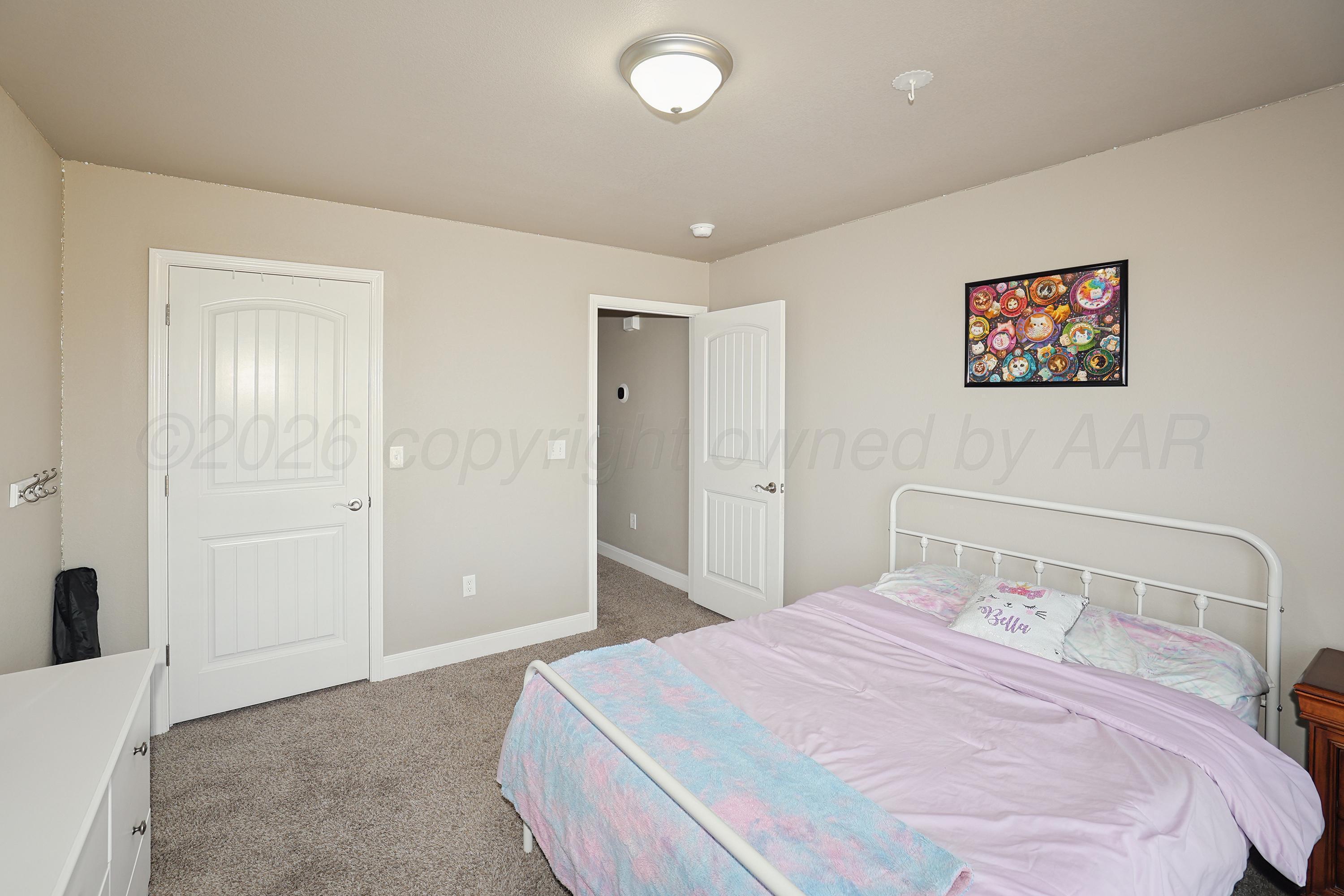 9715 Mossberg Street Canyon, TX 79015 - Photo 18 of 32 a bedroom with a large bed and a walk in closet