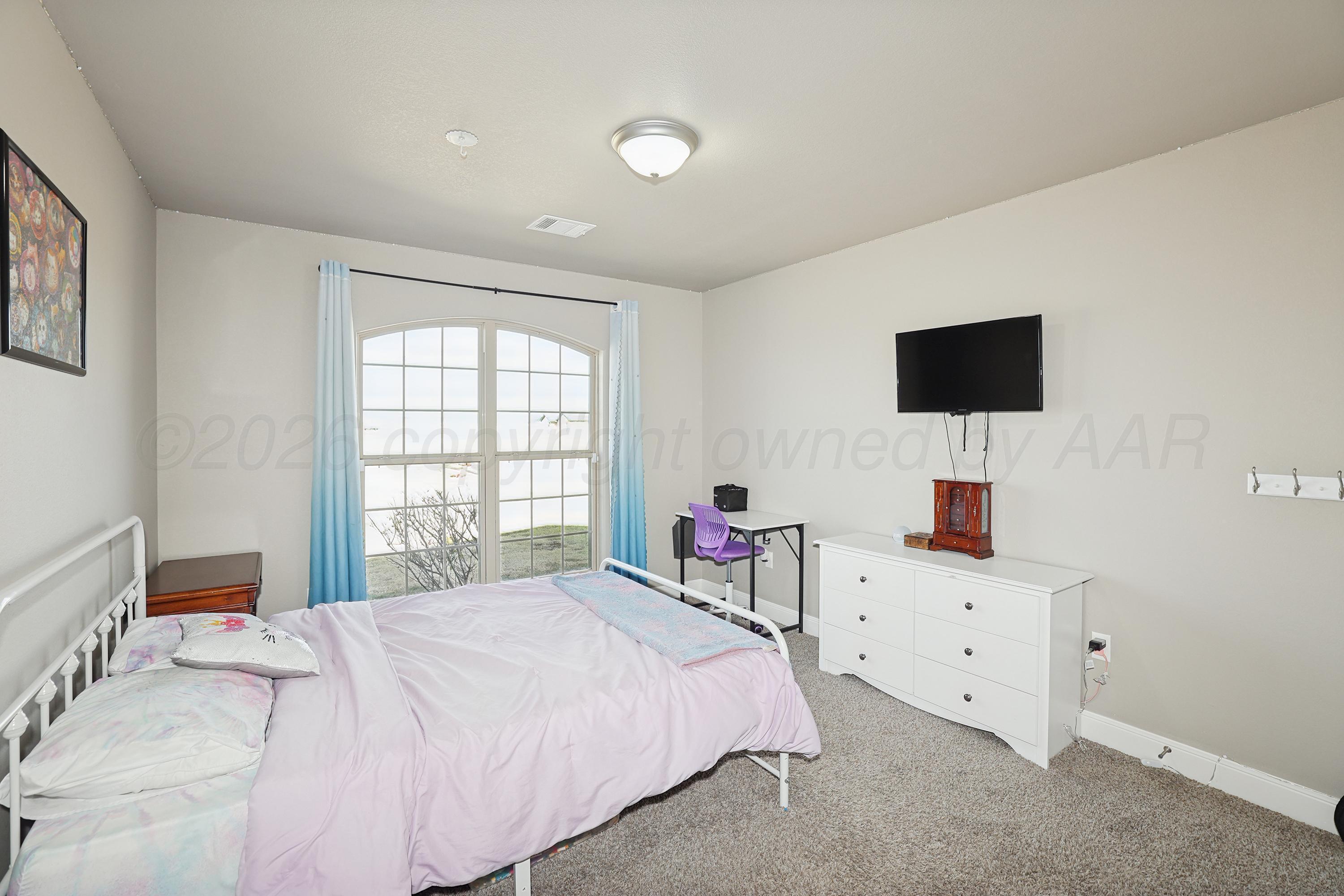 9715 Mossberg Street Canyon, TX 79015 - Photo 19 of 32 a bedroom with a bed and a flat screen tv