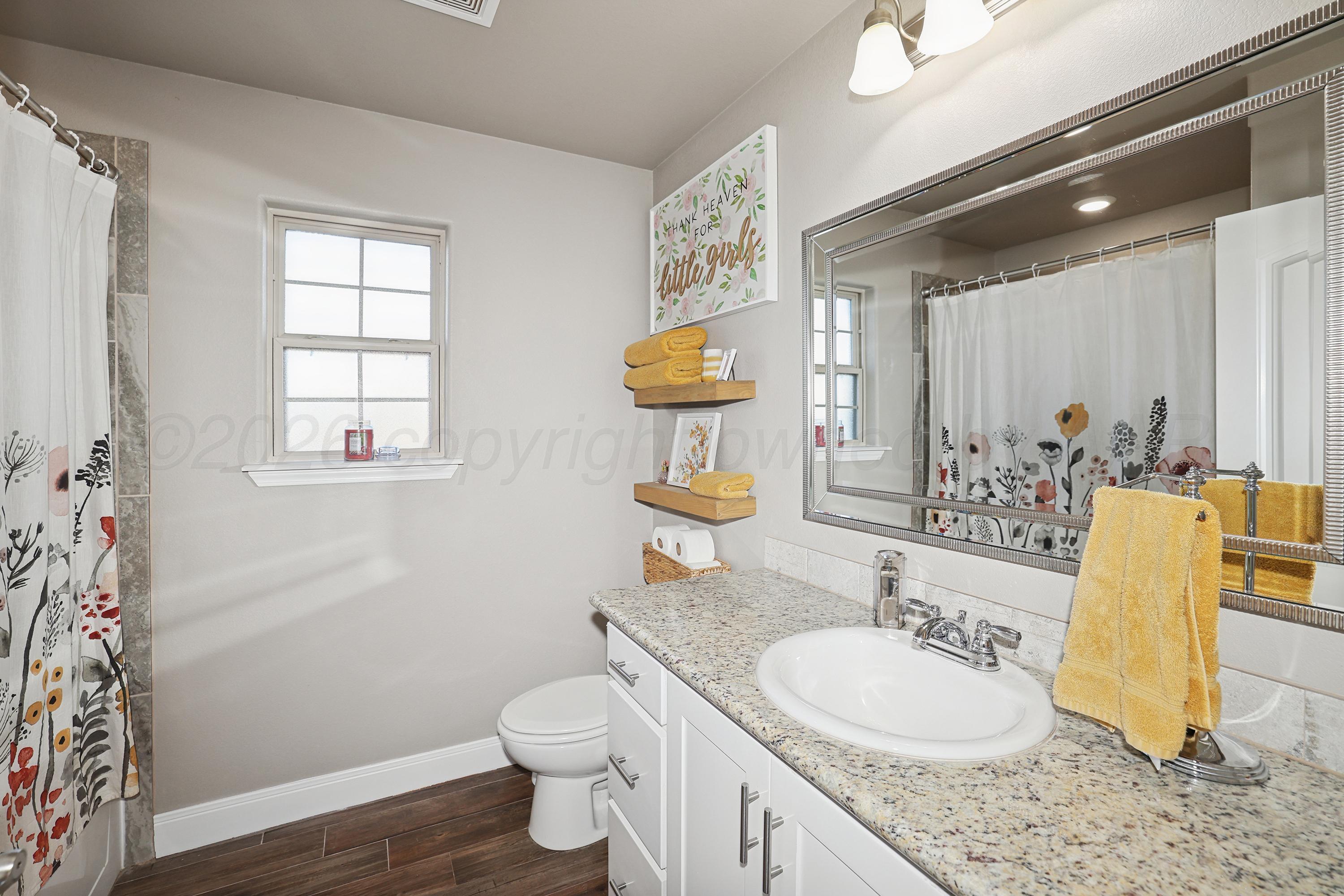 9715 Mossberg Street Canyon, TX 79015 - Photo 22 of 32 a bathroom with a granite countertop toilet sink and mirror