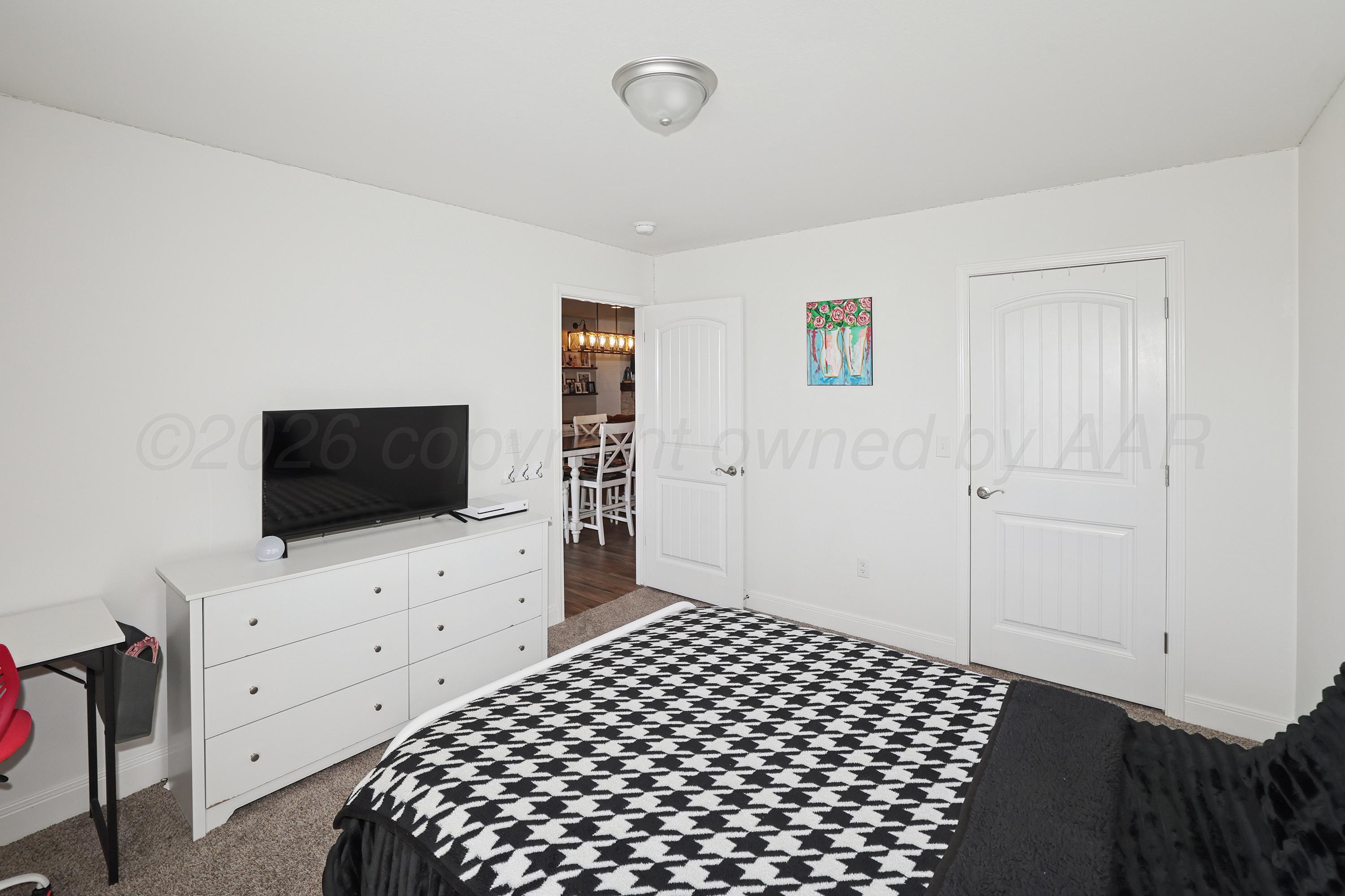 9715 Mossberg Street Canyon, TX 79015 - Photo 24 of 32 a bedroom with a bed and flat screen tv