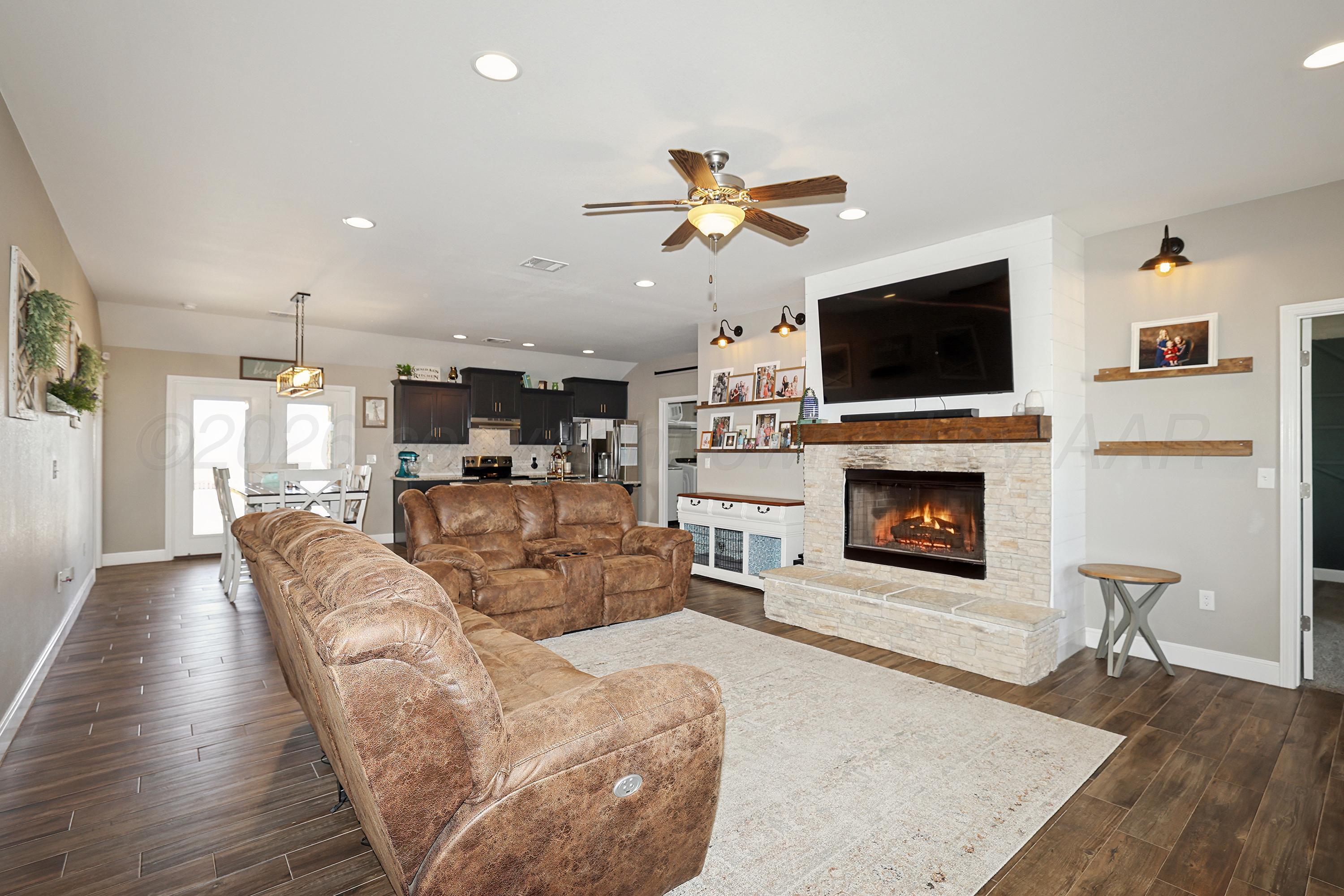9715 Mossberg Street Canyon, TX 79015 - Photo 31 of 32 a living room with furniture a fireplace and a flat screen tv