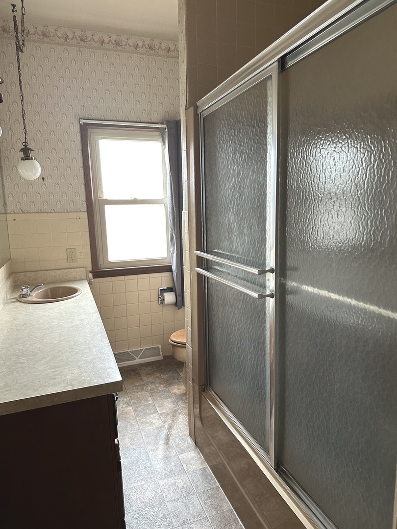 303 South Pleasant Street Princeton, IL 61356 - Photo 16 of 20 a bathroom with a granite countertop sink mirror and shower