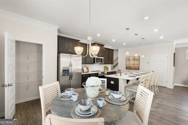 a kitchen with stainless steel appliances kitchen island granite countertop a dining table and chairs