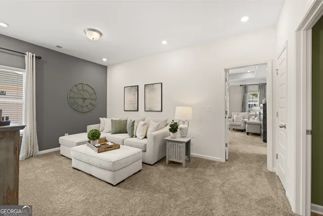 a living room with furniture a flat screen tv and a window