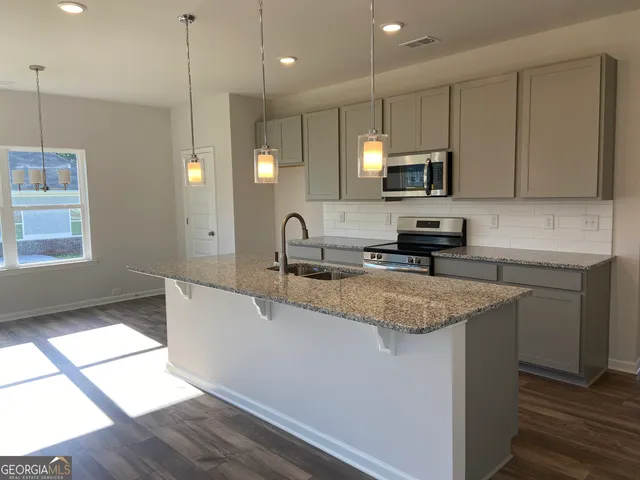 a kitchen with stainless steel appliances granite countertop a sink a stove and a granite counter tops