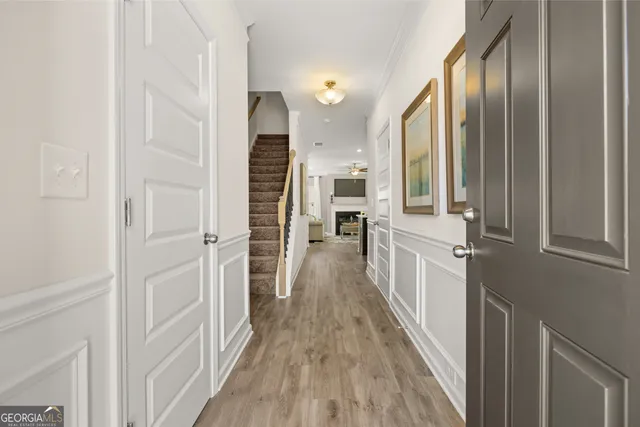a view of a hallway with wooden floor and staircase