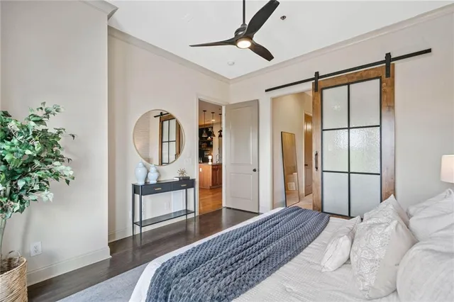 a bedroom with a large bed and a potted plant