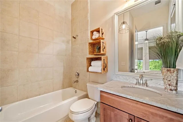 a bathroom with a granite countertop sink a toilet and shower
