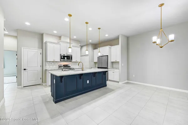 a kitchen with a sink a counter space appliances and cabinets