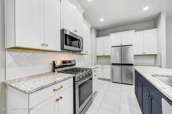 a kitchen with a sink a counter space appliances and cabinets