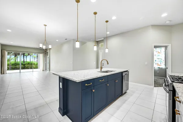 a kitchen with a sink a center island stainless steel appliances and cabinets
