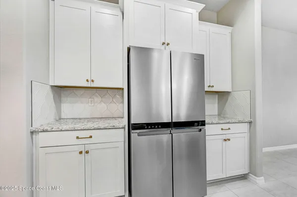 a view of an empty room with window and chandelier fan