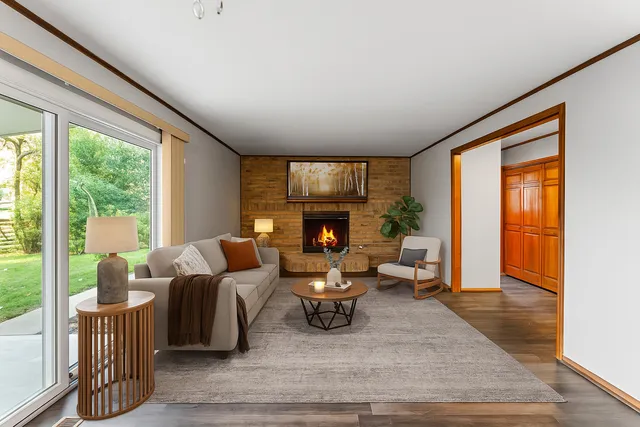 a living room with furniture large window and a fireplace