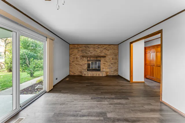 a view of an empty room with a fireplace and a window