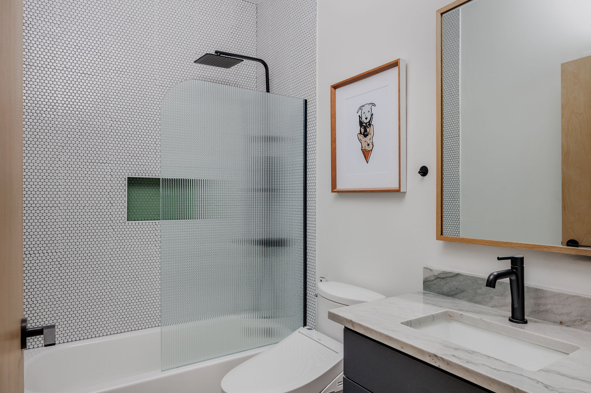 1605 Maple Avenue Austin, TX 78702 - Photo 16 of 33 Contemporary bathroom featuring a tub and shower combination with a textured glass partition, a recessed shower niche, and a matte black rainfall shower head