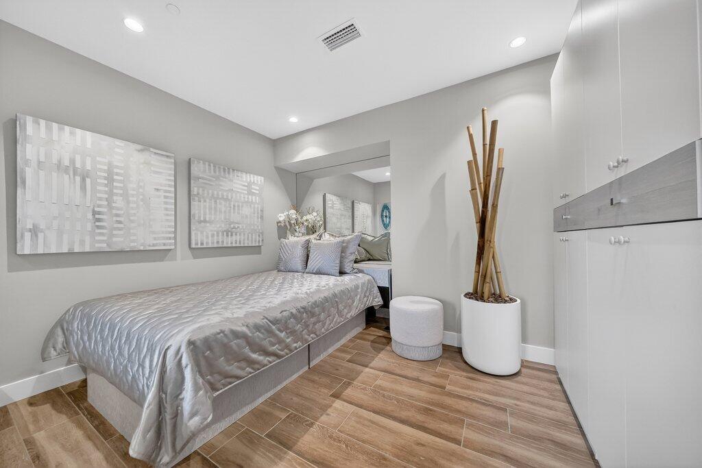 41 Southwest Seminole Street, Unit 304 Stuart, FL 34994 - Photo 11 of 29 a spacious bedroom with a bed and a table