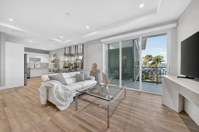 a living room with furniture a flat screen tv and a large window