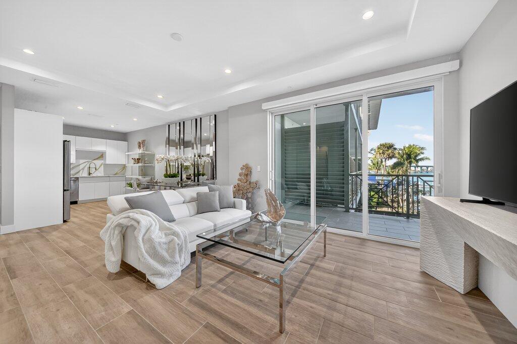 41 Southwest Seminole Street, Unit 304 Stuart, FL 34994 - Photo 2 of 29 a living room with furniture a flat screen tv and a large window