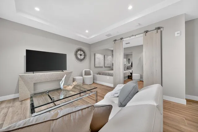 a living room with furniture a flat screen tv and kitchen view