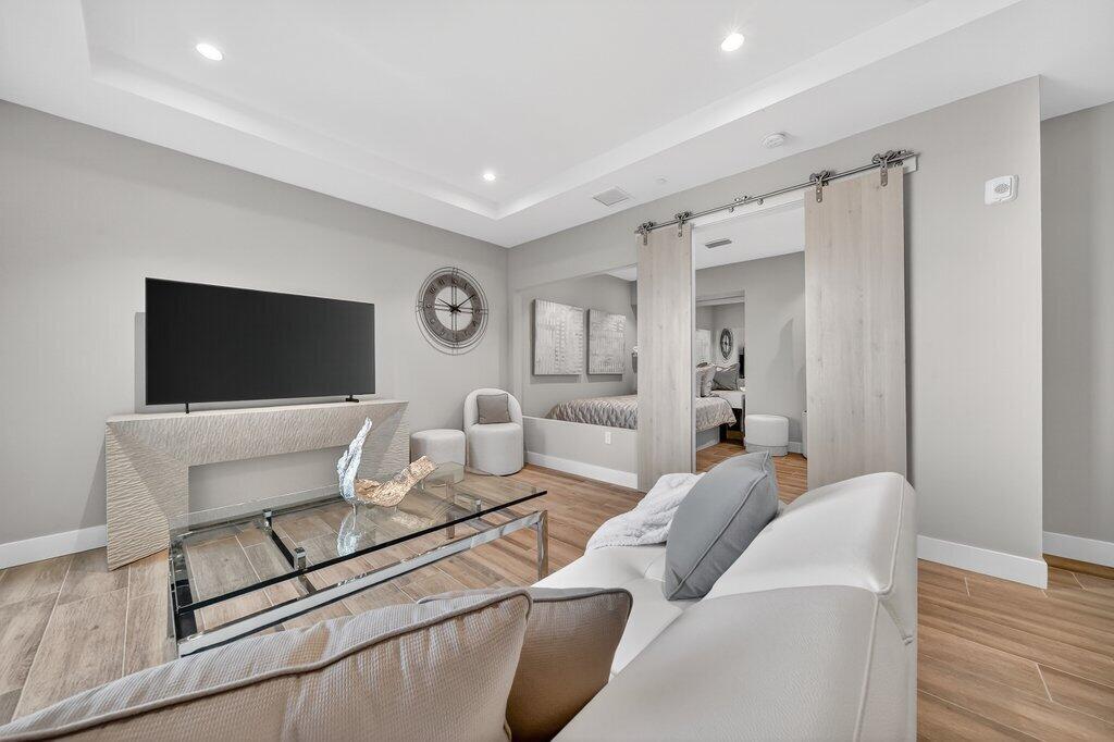 41 Southwest Seminole Street, Unit 304 Stuart, FL 34994 - Photo 3 of 29 a living room with furniture a flat screen tv and kitchen view