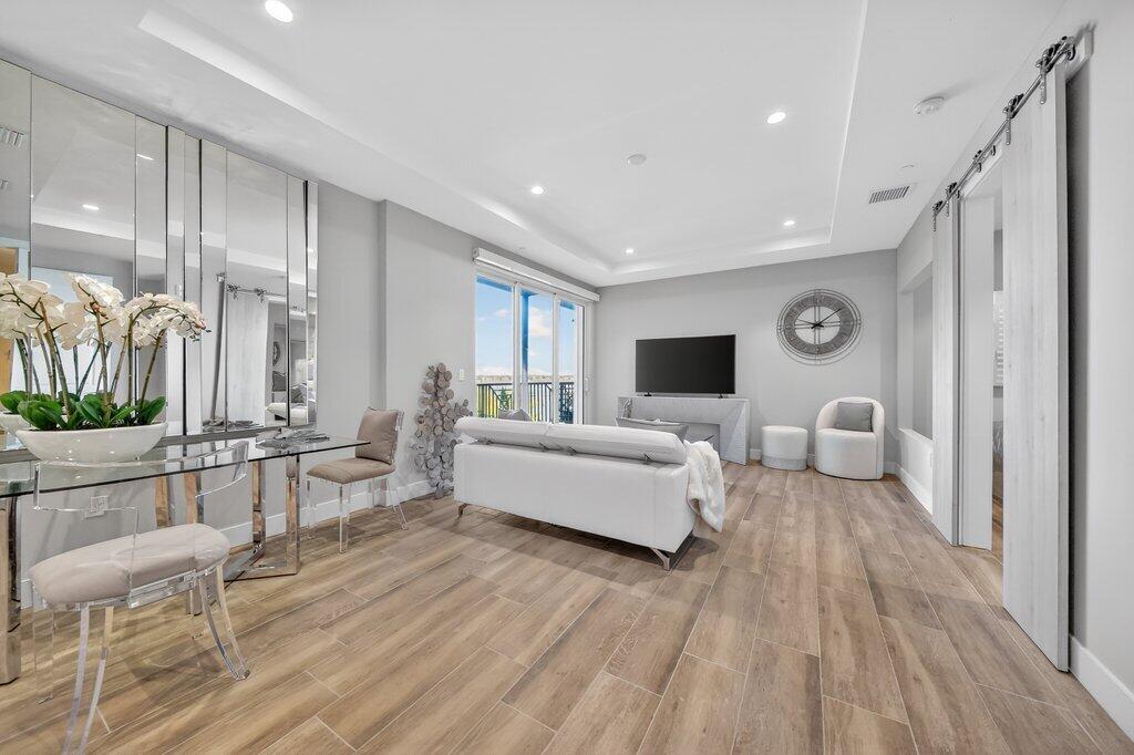 41 Southwest Seminole Street, Unit 304 Stuart, FL 34994 - Photo 5 of 29 a living room with furniture and a wooden floor