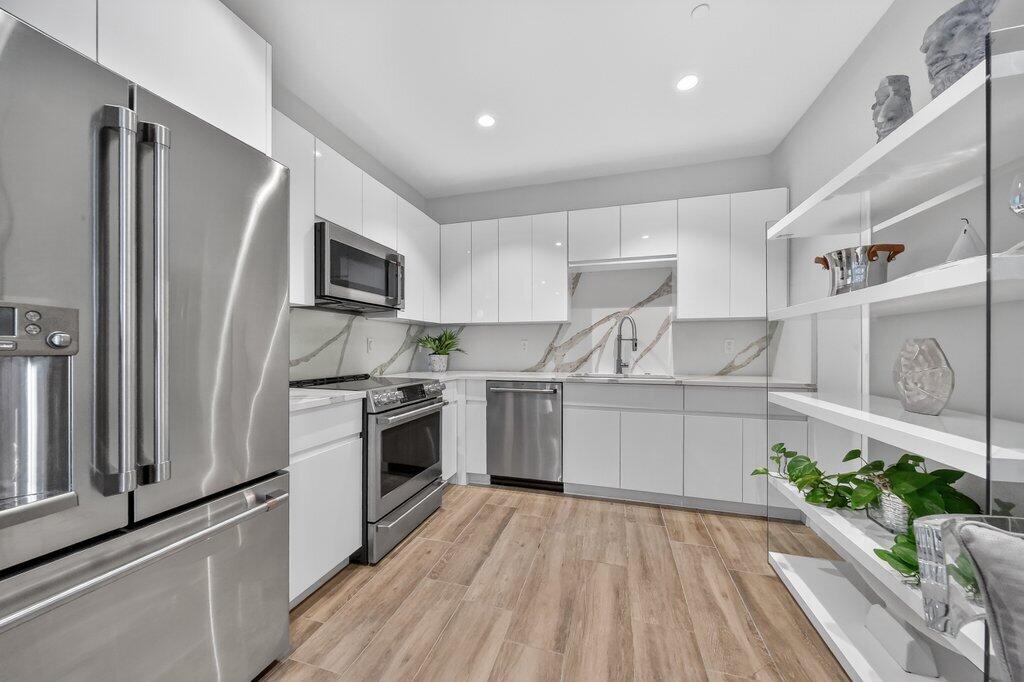 41 Southwest Seminole Street, Unit 304 Stuart, FL 34994 - Photo 9 of 29 a kitchen with a sink stainless steel appliances and cabinets