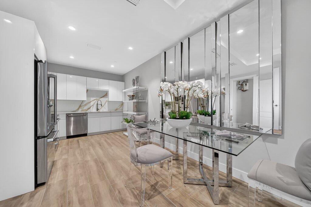 41 Southwest Seminole Street, Unit 304 Stuart, FL 34994 - Photo 10 of 29 a kitchen with white cabinets and chandelier
