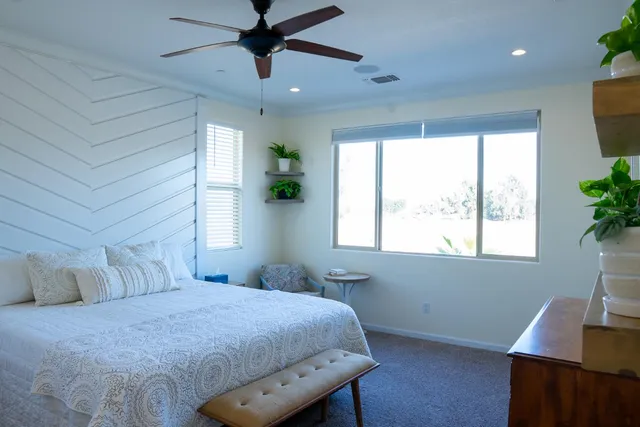a bedroom with a bed and a potted plant