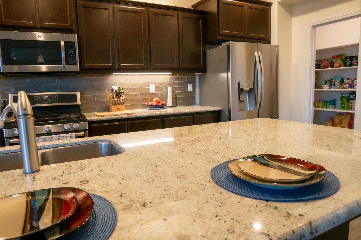 470 Daphne Lane Lemoore, CA 93245 - Photo 6 of 86 a kitchen with stainless steel appliances wooden cabinets and a counter top space