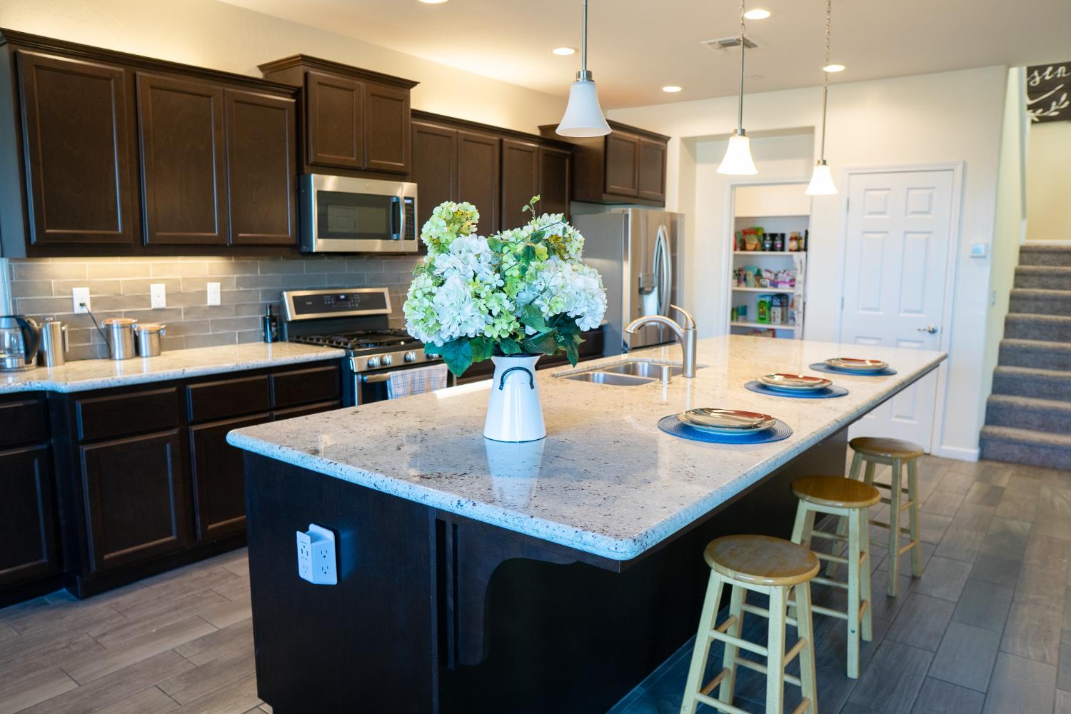 470 Daphne Lane Lemoore, CA 93245 - Photo 64 of 86 a kitchen with stainless steel appliances kitchen island granite countertop a kitchen island a stove a table and chairs