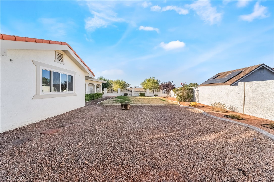 429 Crestway Road Henderson, NV 89015 - Photo 47 of 56 A spacious, rock-covered backyard provides a low-maintenance outdoor living area with a solar-equipped structure nearby.