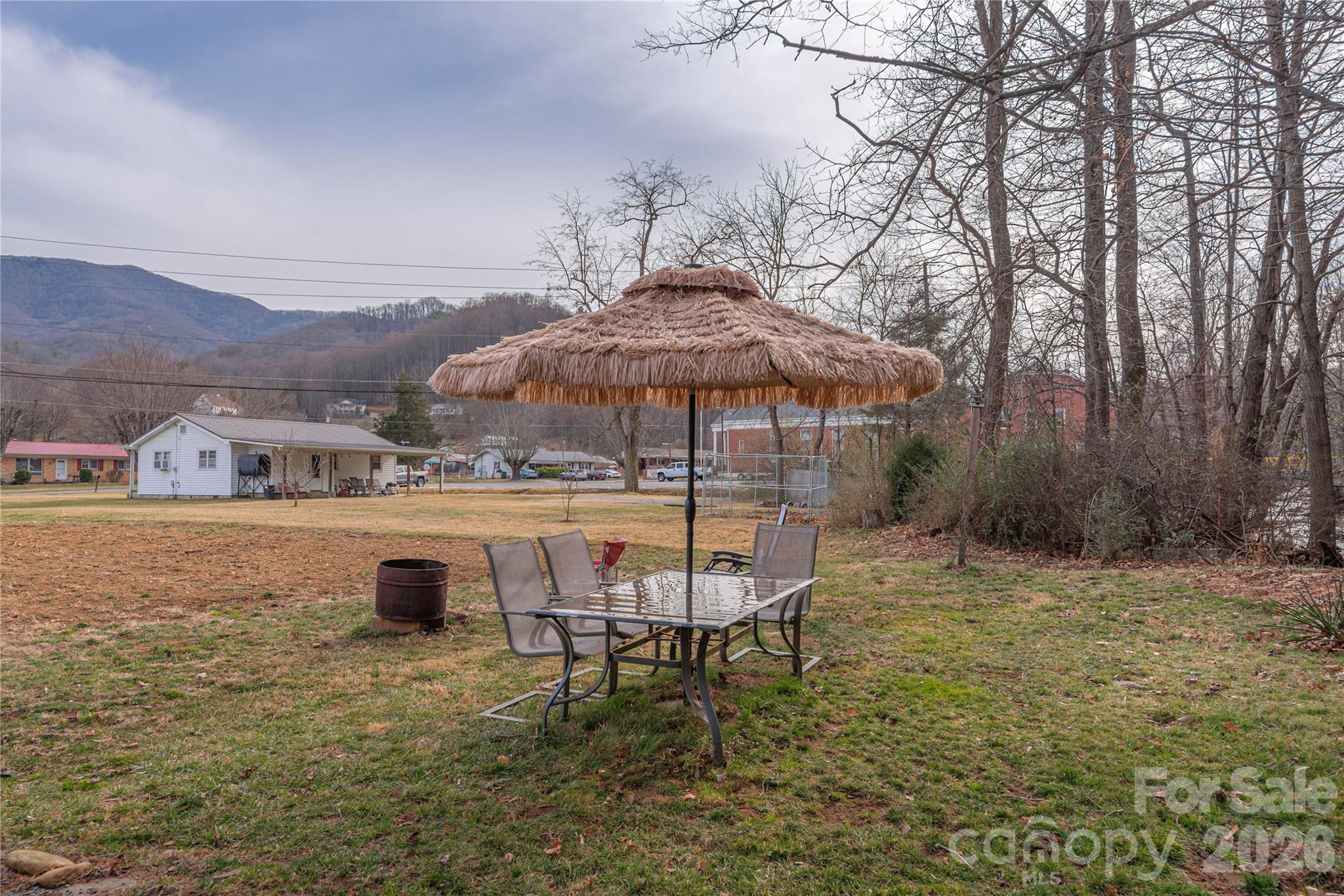 1496 Allens Creek Road Waynesville, NC 28786 - Photo 20 of 25 a backyard of a house with table and chairs