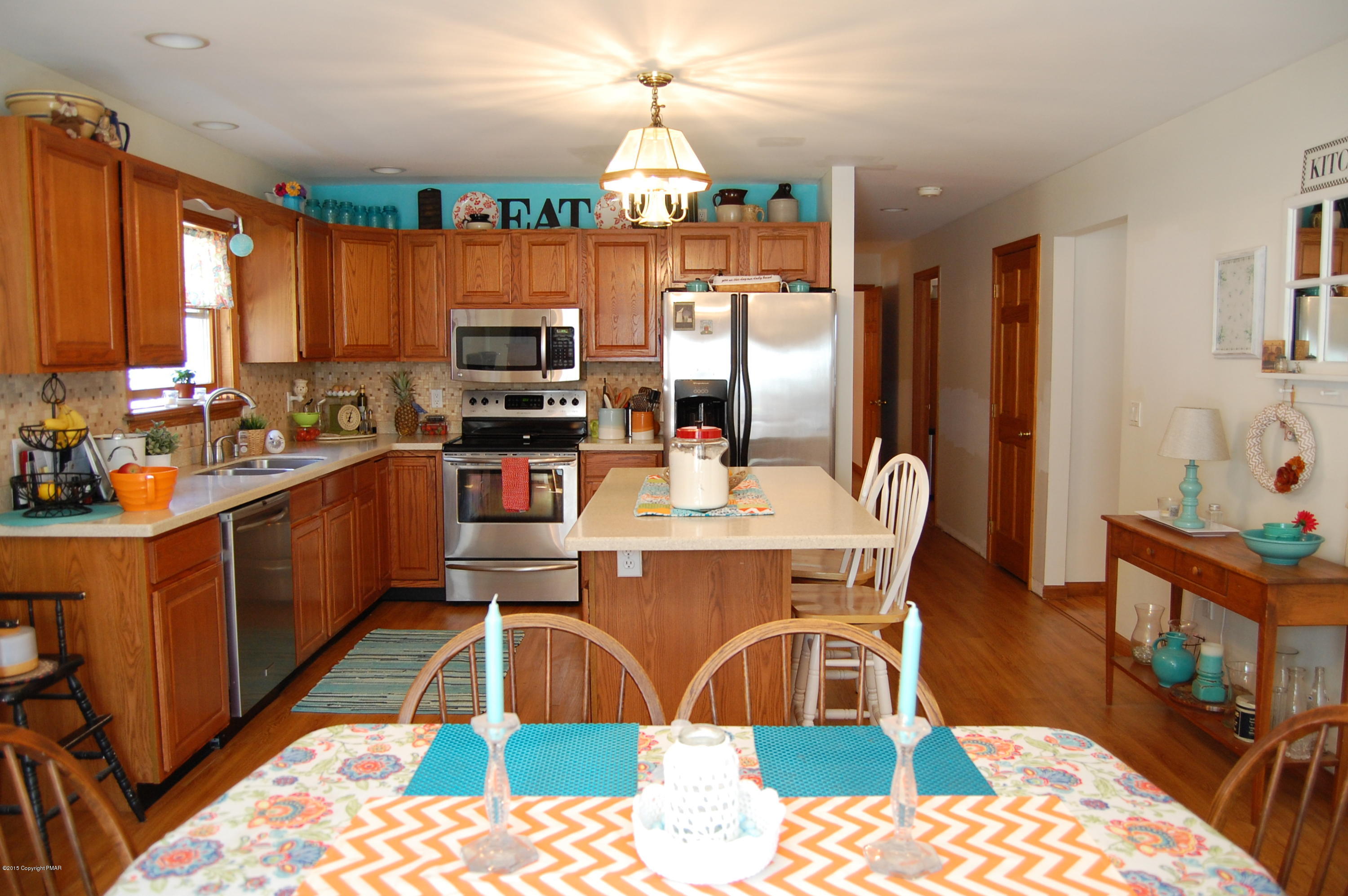 201 Grange Road Mount Pocono, PA 18344 - Photo 7 of 27 a kitchen with stainless steel appliances kitchen island granite countertop a sink dishwasher a dining table and chairs with wooden floor