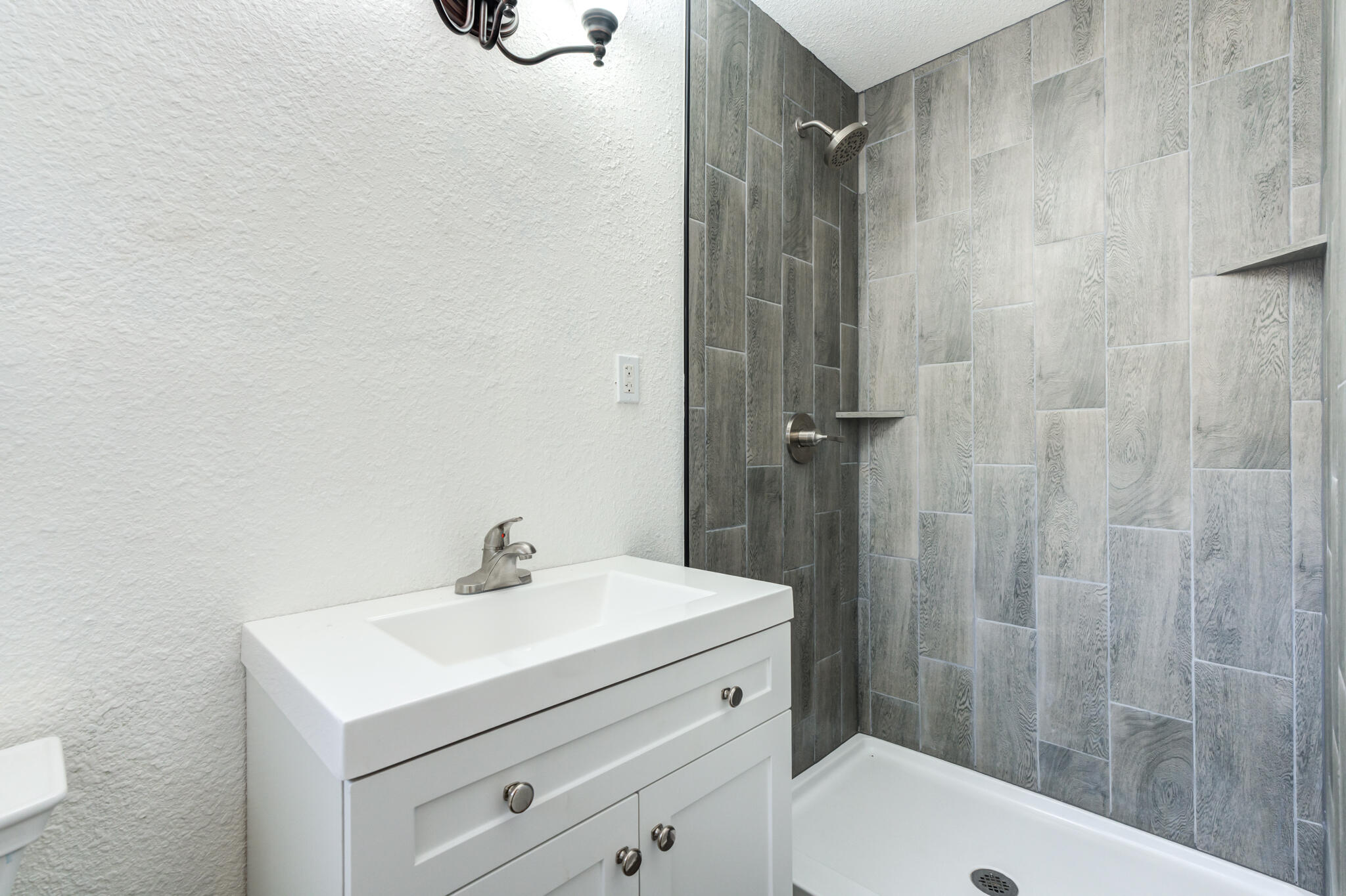 3511 44th Street Lubbock, TX 79413 - Photo 21 of 24 a bathroom with a sink a shower and a mirror