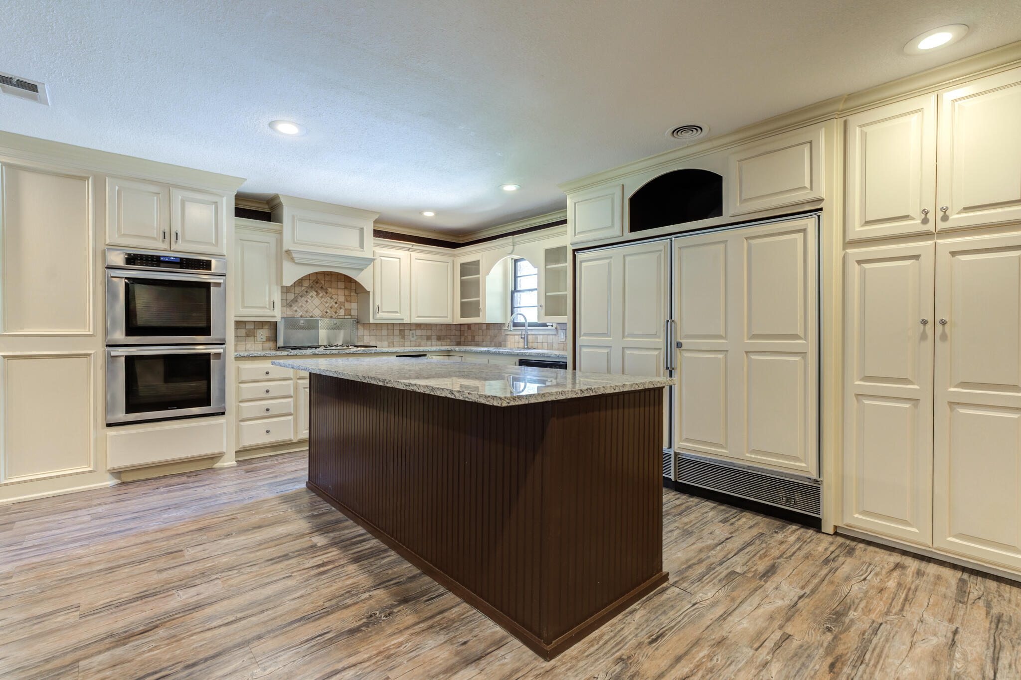 3511 44th Street Lubbock, TX 79413 - Photo 5 of 24 a kitchen with kitchen island white cabinets and refrigerator