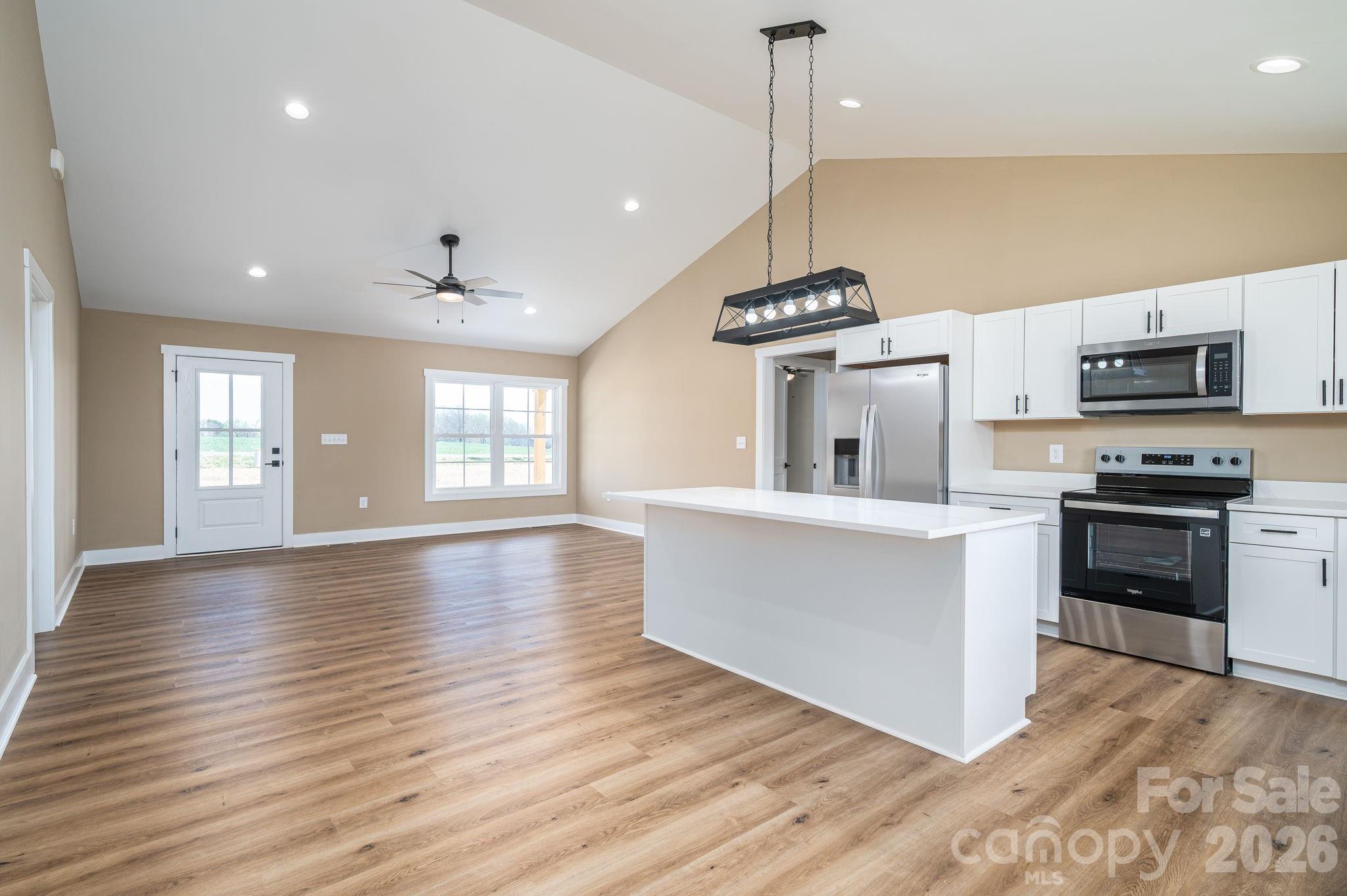 347 Old Belwood Road Lawndale, NC 28090 - Photo 10 of 31 a large kitchen with kitchen island a stove a sink a center island and wooden floor