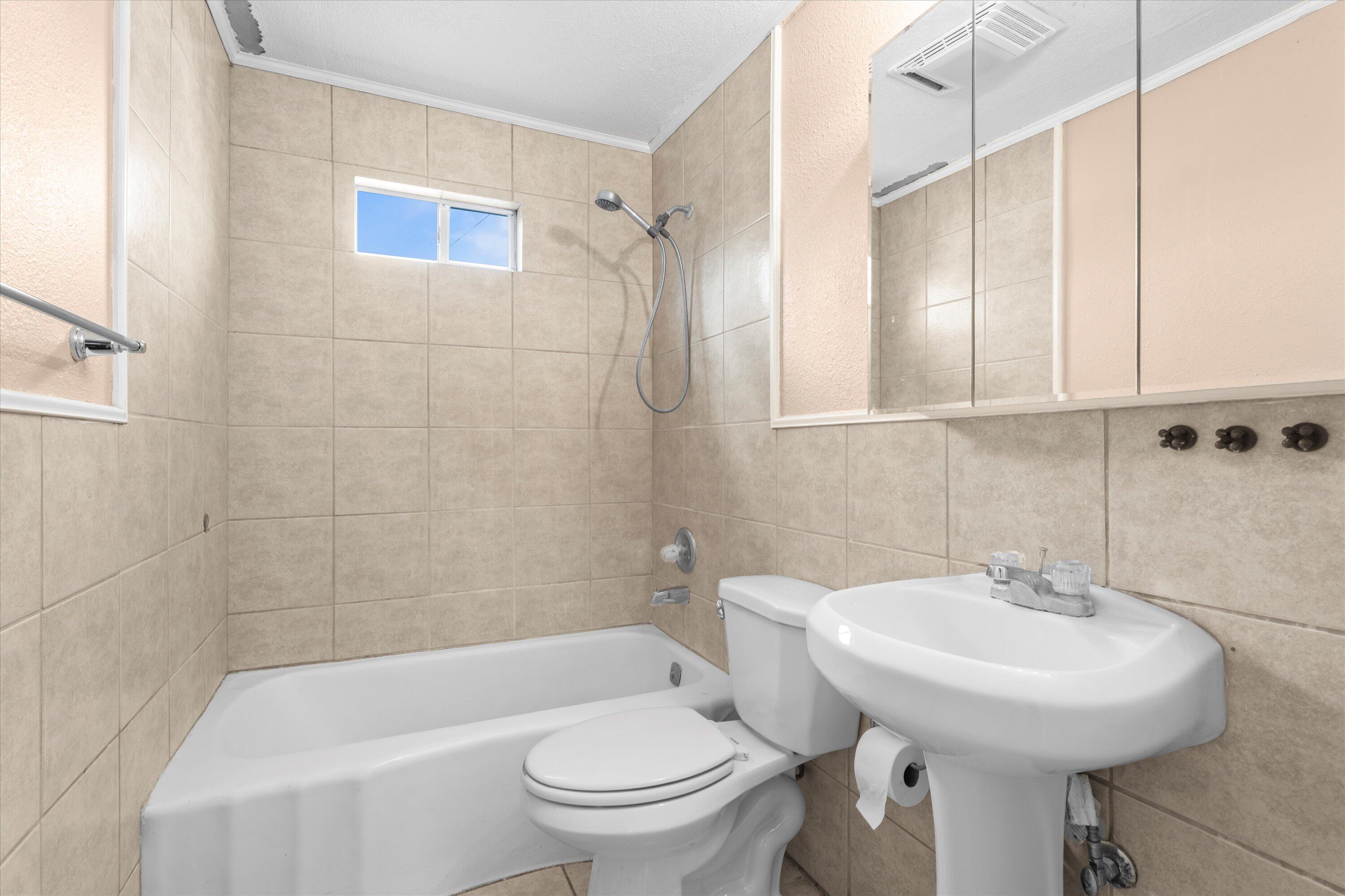 4315 33rd Street Lubbock, TX 79410 - Photo 11 of 16 a bathroom with a sink a toilet and shower